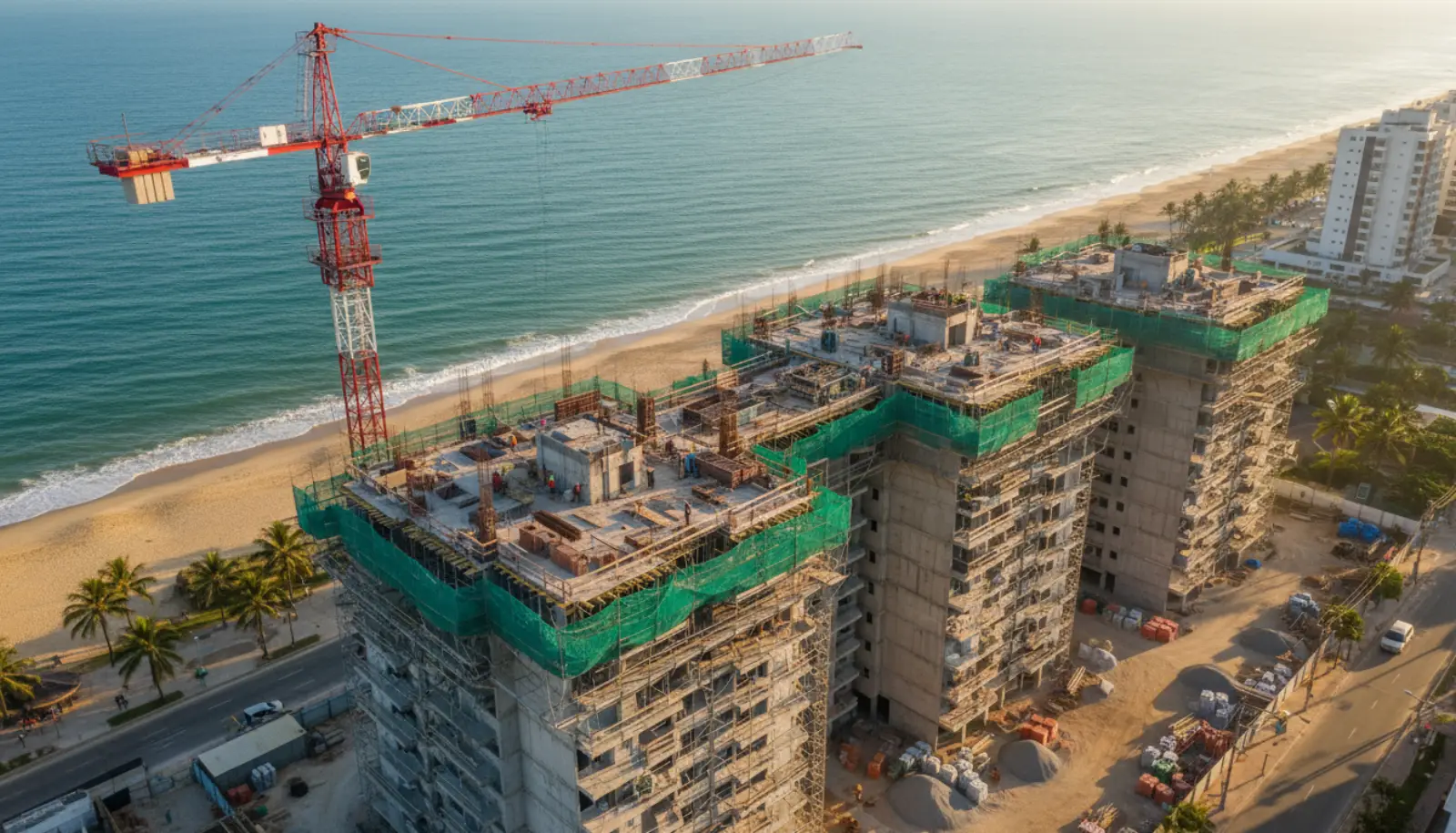 Canteiro de obras de prédio residencial na costa de Santa Catarina, com guindaste e mar ao fundo